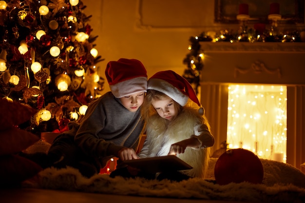 Enfants excités près de l'arbre de Noël