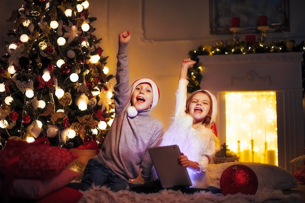 Enfants excités près de l'arbre de Noël