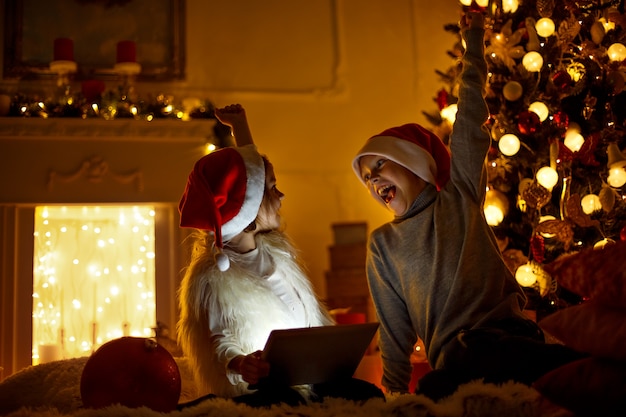 Photo enfants excités près de l'arbre de noël