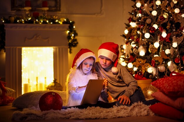 Enfants excités près de l'arbre de Noël