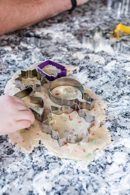 Enfants faisant des biscuits avec la famille pour Noël.