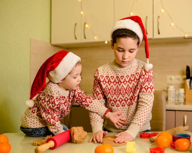 Enfants faisant des biscuits pour le Père Noël dans la cuisine