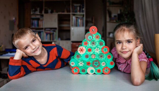 Enfants faisant le calendrier de l'Avent de Noël à la main avec des rouleaux de papier toilette à la maison