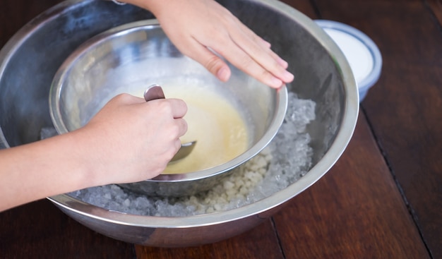 Enfants faisant la crème glacée faite maison avec le bol glacé.