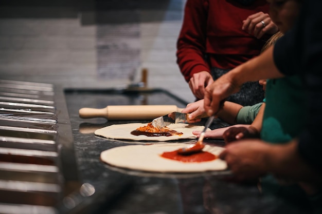 enfants faisant une pizza maison à la tomate