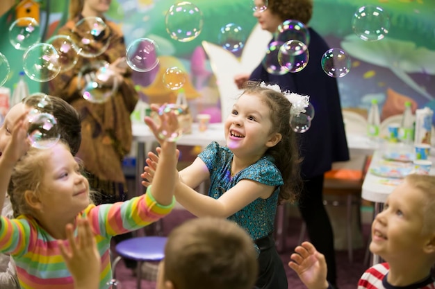 Photo enfants à la fête spectacle de bulles de savon fête d'enfants faire éclater le savon