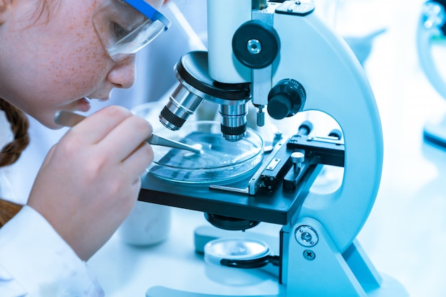Enfants fille scientifiques faisant des expériences chimiques au microscope dans la salle de laboratoire. Concept de science et de l'éducation.