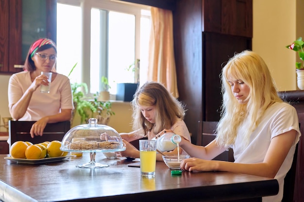 Enfants de filles de famille mangeant à la table dans la cuisine