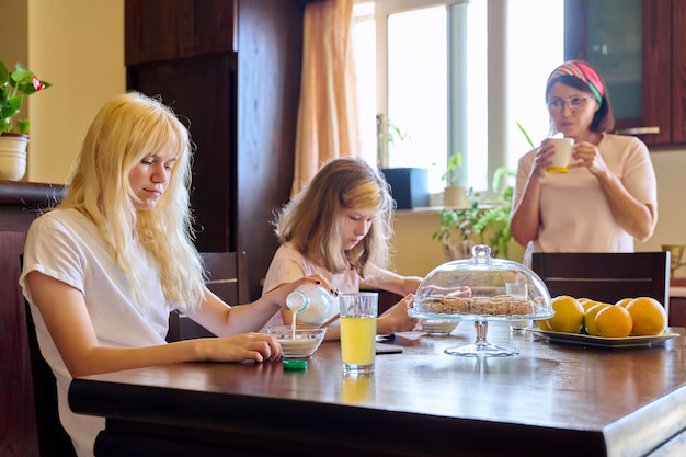 Enfants de filles de famille mangeant à la table dans la cuisine