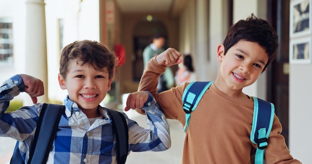 Les enfants flex ou portrait et l'école pour l'éducation croissance ou heureux pour l'apprentissage opportunité garçons sourire ou geste fort dans le couloir pour l'énergie de la puissance cérébrale ou montrant le muscle pour le développement des connaissances