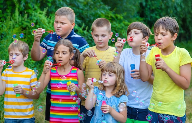 Des enfants font des bulles dans la rue. Mise au point sélective.