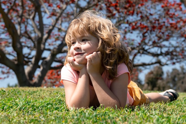 Les enfants font face à un petit garçon allongé sur l'herbe