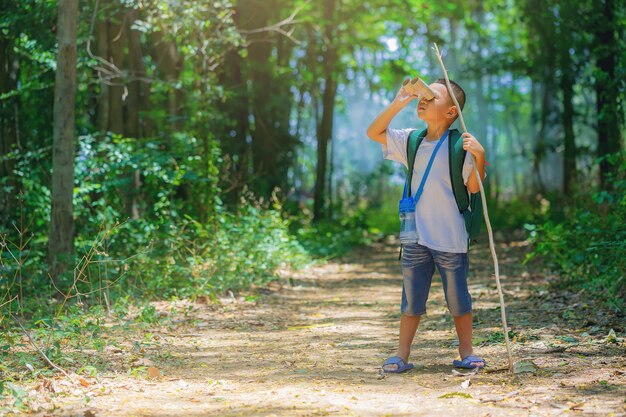 Les enfants font de la randonnée dans la cour avec des sacs à dos à Forest Path Explorer et aventure avec des jumelles jouet