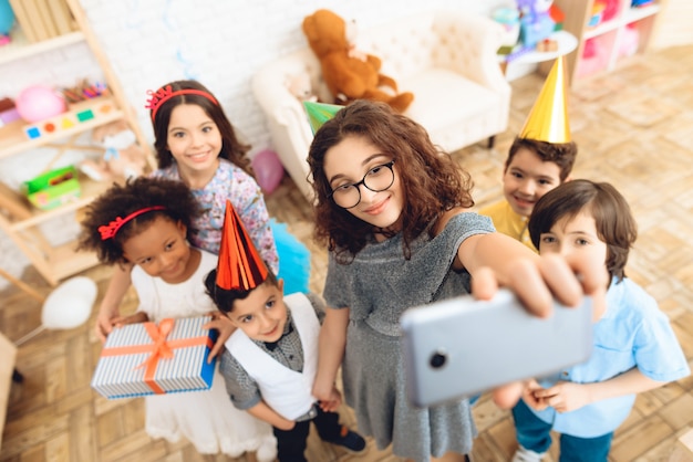 Photo les enfants font selfie ensemble à la fête d'anniversaire.