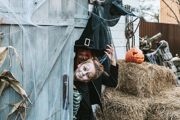 Photo enfants un garçon dans un costume de squelette et une fille dans un costume de sorcière s'amusant à une fête d'halloween