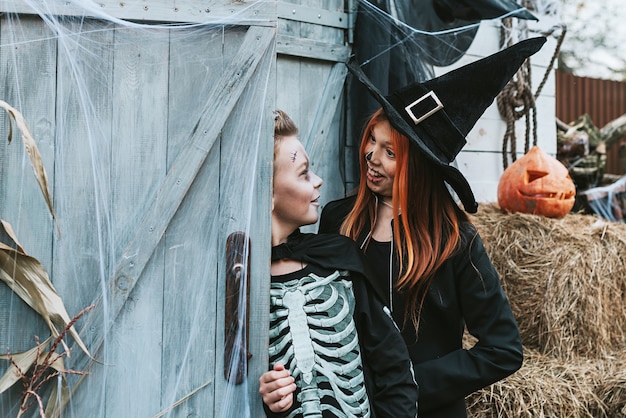 enfants un garçon dans un costume de squelette et une fille dans un costume de sorcière s'amusant à une fête d'halloween