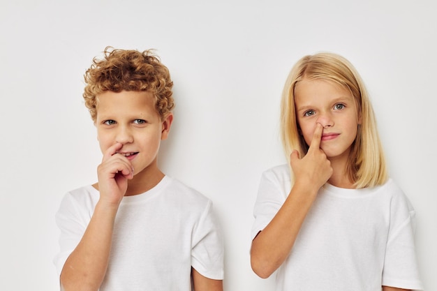 Enfants garçon et fille posant sur fond blanc