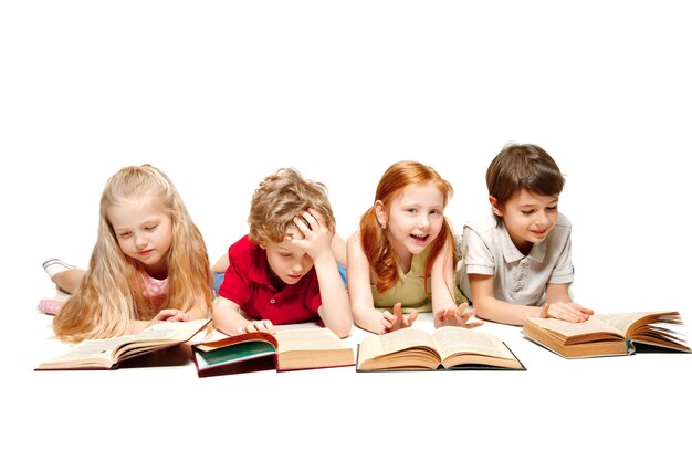 Les Enfants Garçon Et Filles Portant Des Livres Au Studio, Souriant, Riant, Isolés Sur Blanc. Journée Du Livre, De L'éducation, De L'école, De L'enfant, De La Connaissance, De L'enfance, De L'amitié, De L'étude Et Du Concept Des Enfants