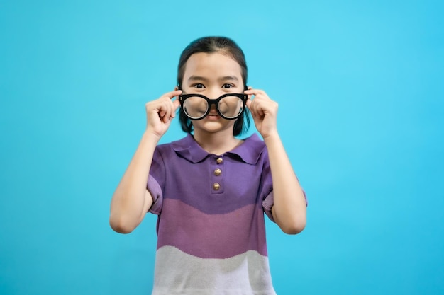 Enfants en gros plan photo de personnes mignonnes et gaies, portant des lunettes regardant et souriant sur de la pâte bleue