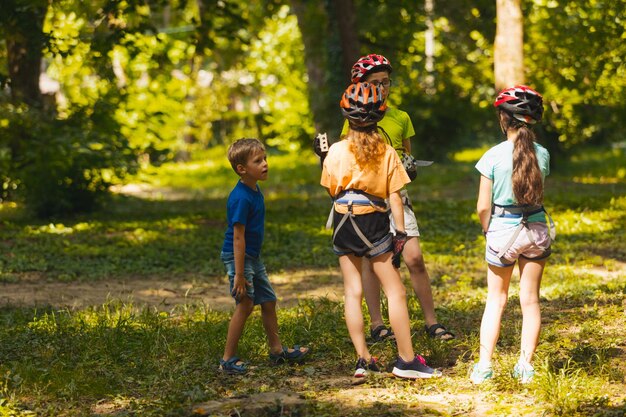 Des enfants sur l'herbe contre les arbres.