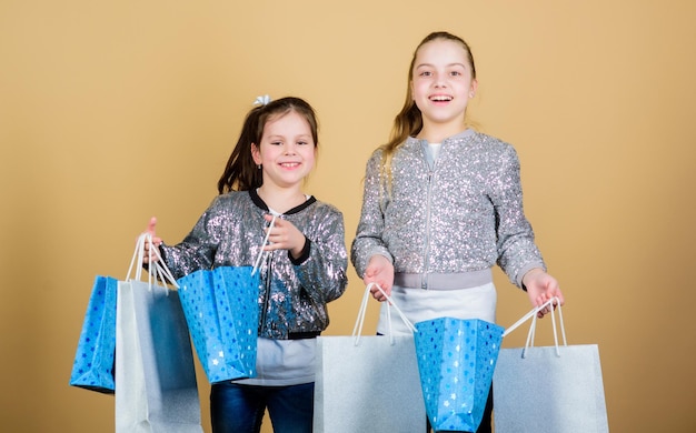 Enfants heureux Achats en ligne de petites sœurs Ventes et remises Économies de la fraternité et de la famille sur les achats Assistant de magasin de mode pour enfants avec forfait Petites filles avec des sacs à provisions