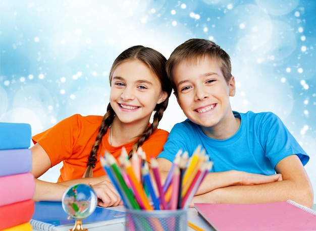 Enfants heureux assis près de la table pendant la leçon