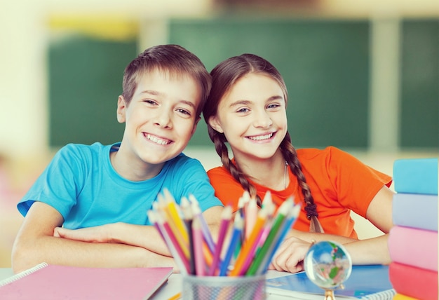 Enfants heureux assis près de la table pendant la leçon