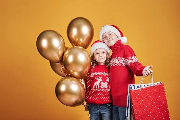 Enfants heureux avec des cadeaux de Noël et des ballons