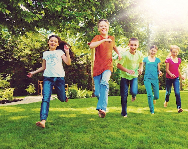 Enfants heureux courir et jouer dans le jardin aux beaux jours