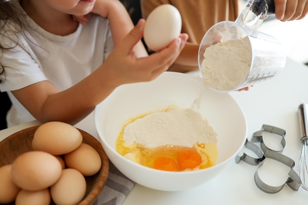 Des enfants heureux dans la cuisine font des biscuits Master class de cuisine