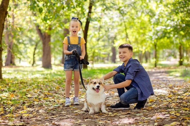 Enfants heureux dans le parc jouant avec leur chien