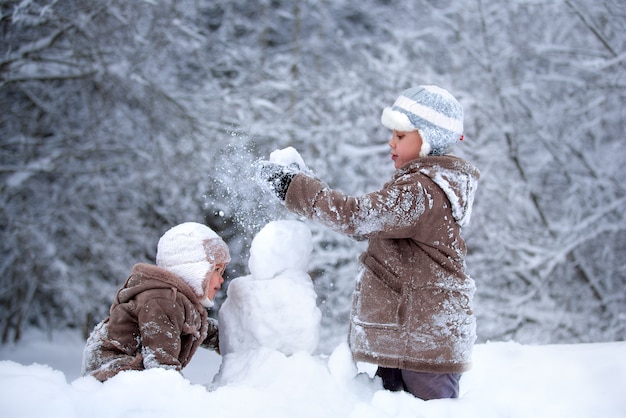 Photo enfants heureux jouant dans la neige