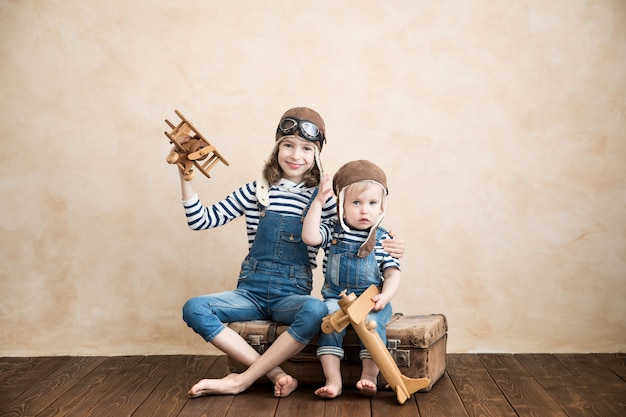 Enfants heureux jouant à la maison. Bébé garçon et fille avec avion jouet