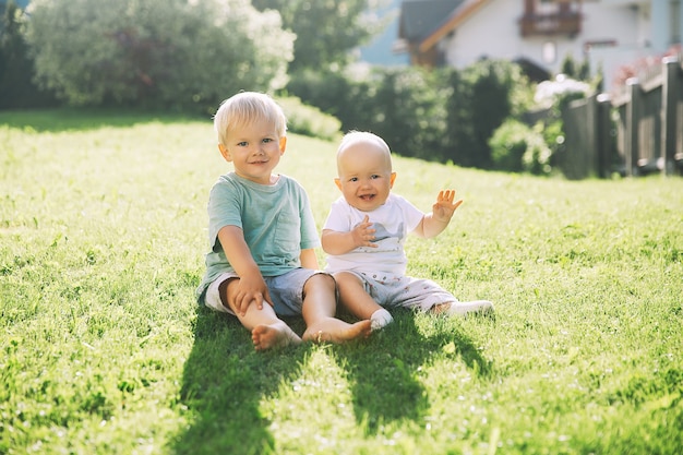 Des enfants heureux jouent sur la nature à l'extérieur Frère et sœur s'amusent ensemble en été à l'extérieur