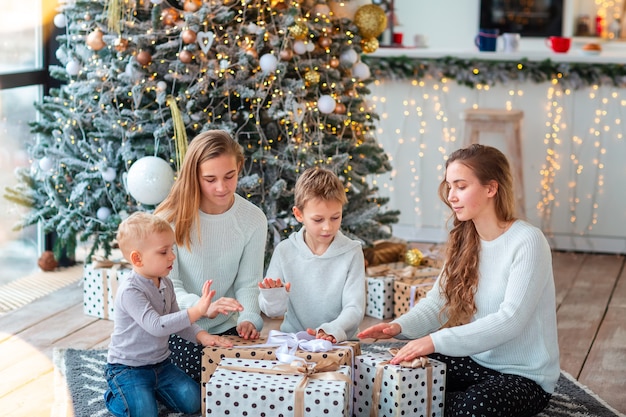 Enfants heureux près de l'arbre de Noël avec les boîtes présentes