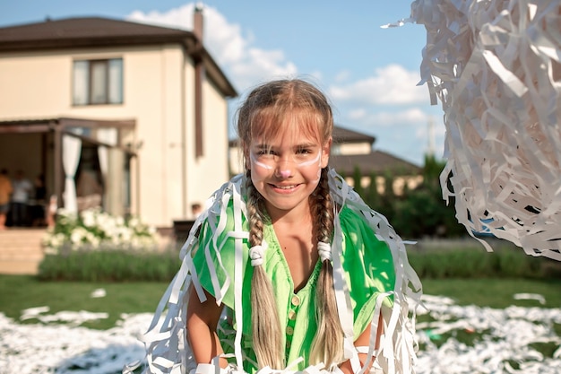 Des enfants heureux profitent d'un spectacle de papier lors d'une fête d'anniversaire en plein air dans le jardin