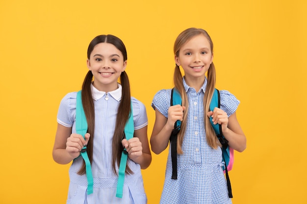 Enfants heureux de retour à l'école le jour de la connaissance 1er septembre fond jaune enfance