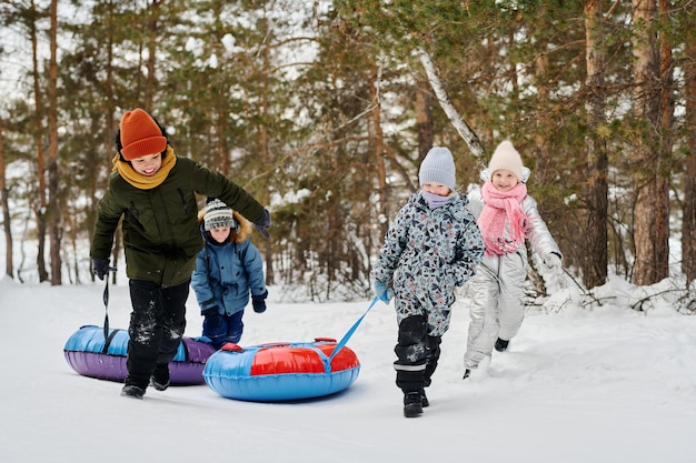 Des enfants heureux tirant des tubes de neige