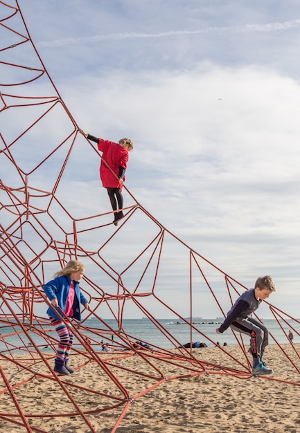 Enfants jouant sur l&#39;aire de jeu avec des cordes sur la plage de Barcelone, Espagne