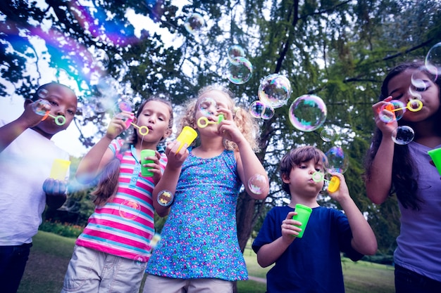 Photo enfants jouant avec la baguette magique dans le parc