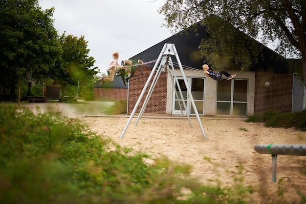 Enfants jouant sur une balançoire sur l'aire de jeux par une journée ensoleillée