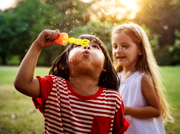 Photo enfants jouant des bulles dans un parc