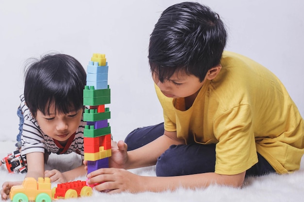 Enfants jouant à construire des bâtiments à l'aide de briques colorées