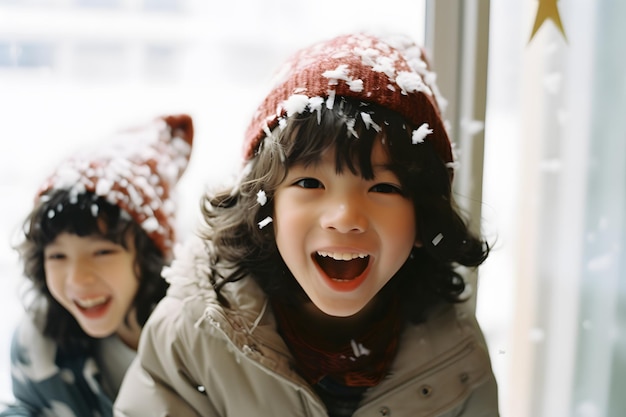 Des enfants jouant dans la neige avec des chapeaux et des foulards de Noël.