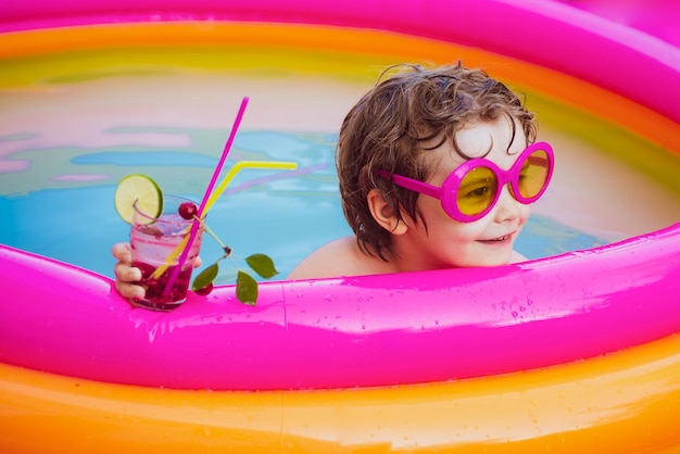 Enfants jouant dans la piscine vacances d'été et concept de vacances les enfants jouent dans un complexe tropical enfant