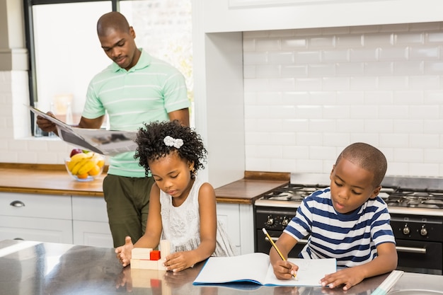 Enfants jouant et dessinant dans la cuisine