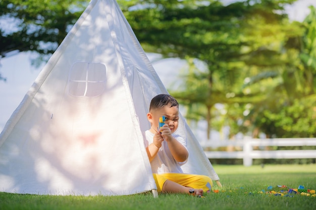 Enfants jouant avec des jouets colorés dans une tente blanche sur le terrain de jeux