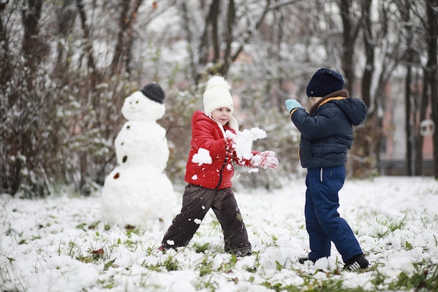 Photo les enfants jouent au parc d'hiver