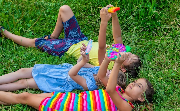 Les enfants jouent au popit anti-stress dans la rue. Mise au point sélective.