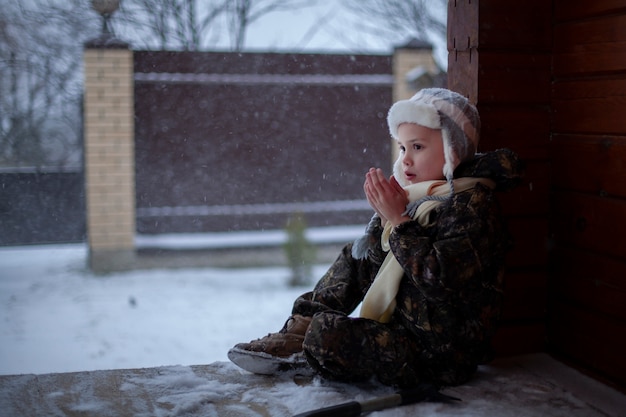 Les enfants jouent dans la neige en hiver